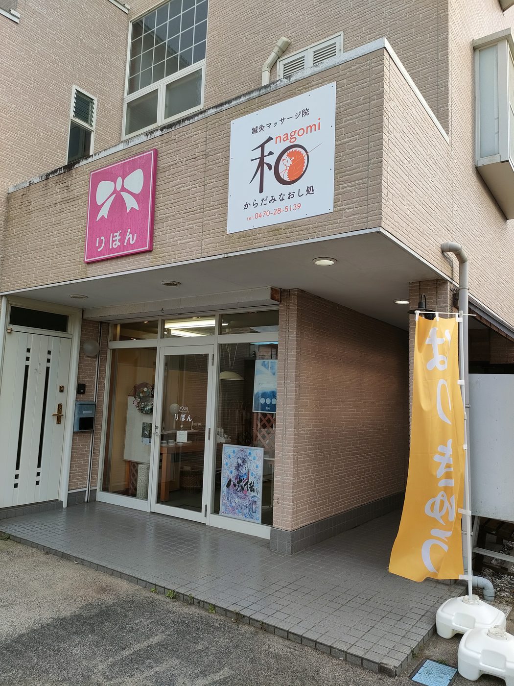 入口の上に付けた「和」のロゴの新しい看板と、となりのピンクの「りぼん」さんの看板